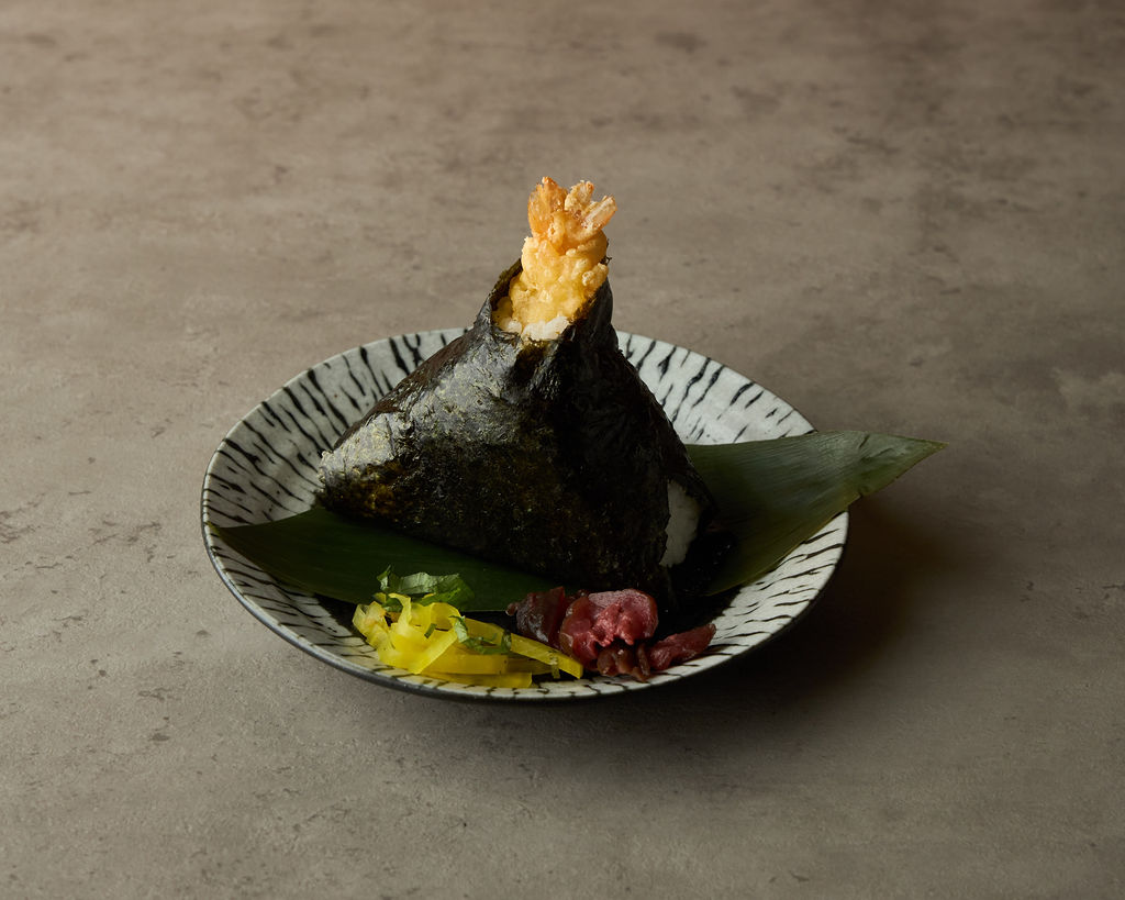 Tenmusu onigiri rice ball with shrimp tempura on a light background